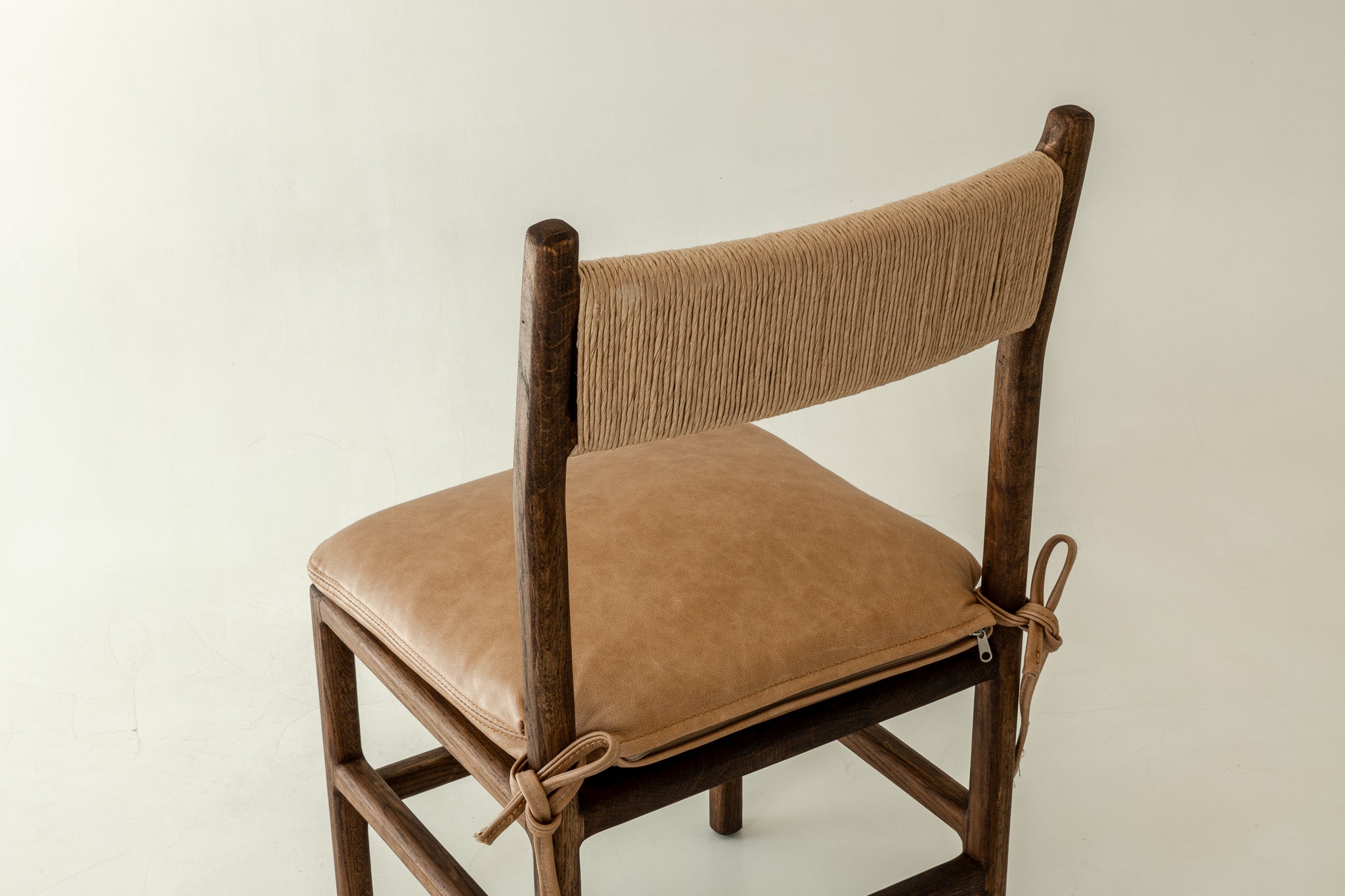 Romi solid oak dining chair in chocolate colour way with leather pillow - close up of back rest